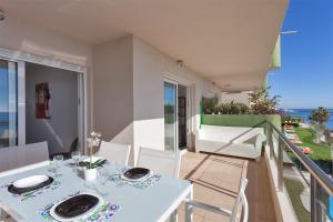 a dining room with a white table and a balcony at Apartamento SAN FERMIN in Benalmádena
