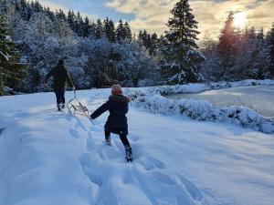 a couple of people walking through the snow at Vintage Racing House in Stavelot