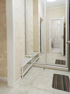 uma casa de banho com um espelho grande e uma cabina de duche ao nível do chão em Затишна і тепла квартира, метро Лівобережна, МВЦ, Інститут Серця em Kiev