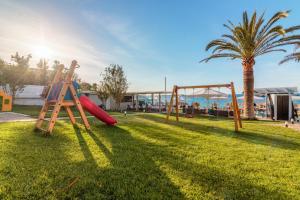 a playground with a slide and a swing set at Hotel Christina in Chania