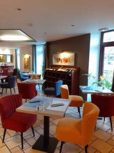 restauracja ze stołami i krzesłami w pokoju w obiekcie Best Western Le Pont d'Or w mieście Figeac