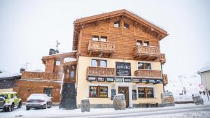 a large wooden building with balconies on a street at Alpino Lodge Bivio in Livigno