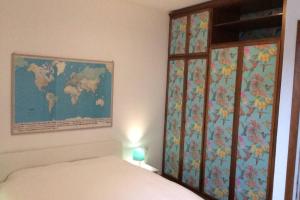 a bedroom with a bed and a map of the world on the wall at Casa Beppino a Castelletto in Brenzone sul Garda
