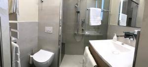 a bathroom with a shower and a toilet and a sink at Hotel Im Engel in Warendorf