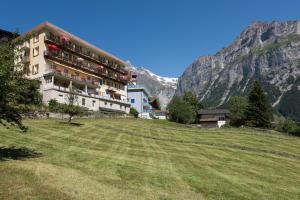 un edificio al lado de una colina con un campo en Bel-Air Eden, en Grindelwald