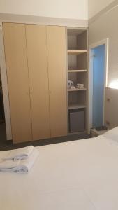 a bedroom with a white bed and a closet at Hotel Augustus in Fano