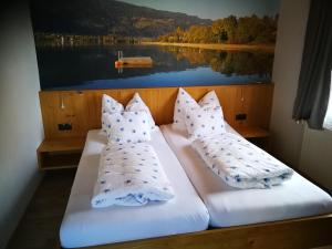 twee kussens op een bed met een foto van een meer bij Fewo Strauss in Ossiach