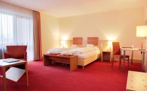a hotel room with a bed and a table and chairs at Hotel am Kurpark in Bad Hersfeld
