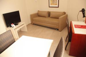 een woonkamer met een bank en een tv bij Lev yerushalayim - suites hotel in Jeruzalem