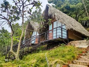 uma casa numa colina com um telhado de relva em Flourish Homestay em Mộc Châu