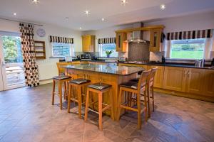a kitchen with a large island with bar stools at Borrowdale View in Keswick