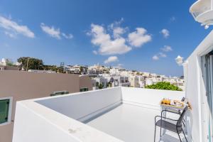 a balcony with a chair and a view of the city at Central Fira Suites in Fira