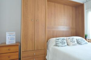 ein Schlafzimmer mit einem Holzschrank neben einem Bett in der Unterkunft RNET - RHC 1410 Roses Holiday Center in Roses + 19 Fotos