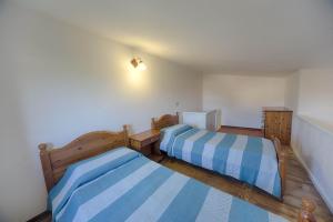 1 dormitorio con 2 camas con rayas azules y blancas en Residence Oasi e Oasi Blu, en San Teodoro