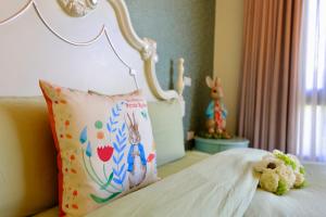 un letto con cuscino e un peluche sopra di Floral Land B&B a Zhixue