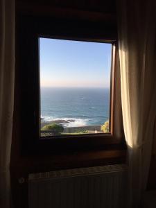 una ventana en una habitación con vistas al océano en Bungalow 3 (adosado) - Playa Arnela, en Carballo