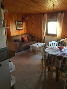 ein Wohnzimmer mit einem Sofa und einem Tisch in der Unterkunft Bungalow 3 (adosado) - Playa Arnela in Carballo