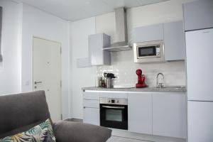 a kitchen with white cabinets and a stove top oven at Apartamento Calma in Vejer de la Frontera