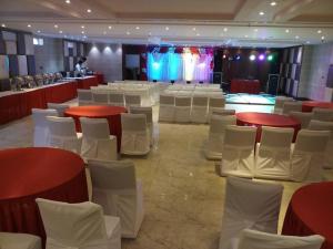 a room with red and white tables and white chairs at Hotel Rudra Vilas in Agra