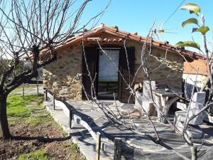 a stone house with a fence in front of it at A casa do Moinho in Pedrógão Pequeno