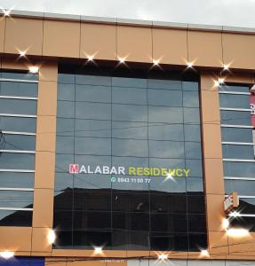 a building with a sign on the side of it at MALABAR Residency in Perintalmanna