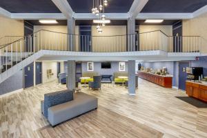 a large lobby with a staircase and tables and chairs at Quality Inn & Suites Apex-Holly Springs in Apex