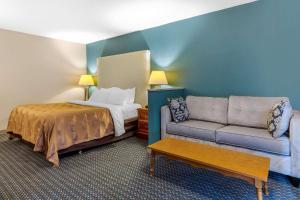 a room with a bed and a couch and a bed and a couch at Quality Inn & Suites Apex-Holly Springs in Apex +21 photos