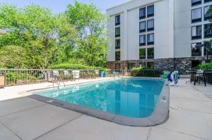 a swimming pool in the courtyard of a building at Comfort Inn Raleigh Midtown in Raleigh