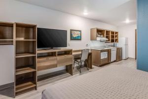 a room with a desk with a television and a bed at WoodSpring Suites Detroit Farmington Hills in Farmington Hills
