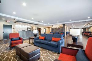 uma sala de estar com um sofá azul e cadeiras vermelhas em Comfort Inn & Suites North Platte I-80 em North Platte