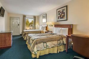 En eller flere senger på et rom på Rodeway Inn & Suites