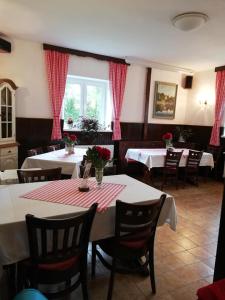ein Esszimmer mit 2 Tischen und Stühlen mit Blumen darauf in der Unterkunft Guesthouse Arnika in Fužine + 37 Fotos