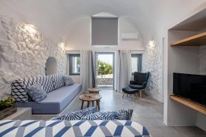 a living room with a blue couch and a chair at Casa Tholari Al Mare in Pera Gyalos