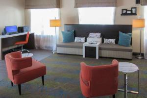 a living room with a couch and chairs and a desk at Sleep Inn & Suites Ft Lauderdale International Airport in Dania Beach