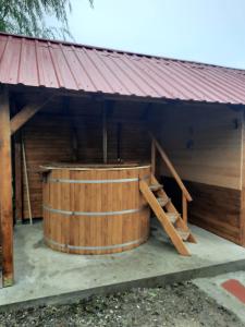 a large wooden hot tub with a red roof at Pensiunea Raul in Tăşnad
