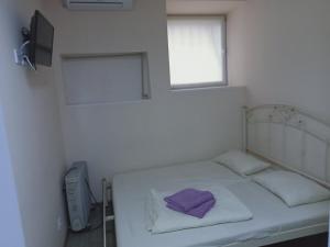 オデッサにあるАдмирал хостелの窓付きのベッドが備わる小さな白い客室です。