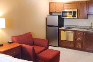 a kitchen with a couch and a chair in a room at Heritage Hotel and Suites in Dickinson