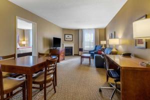a hotel room with a desk and a living room at Comfort Inn & Suites in North Conway