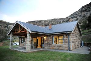 ein Steinhaus mit einem Metalldach in der Unterkunft Oranje Guest Farm in Fouriesburg