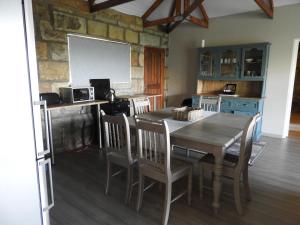 a dining room with a table and chairs and a kitchen at Oranje Guest Farm in Fouriesburg