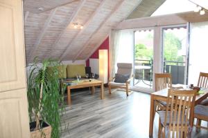 a living room with a wooden ceiling and a table at Ferienwohnungen Lohner Höhe in Bad Sassendorf
