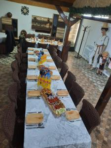 a long table with plates of food on it at Pensiunea Raul in Tăşnad