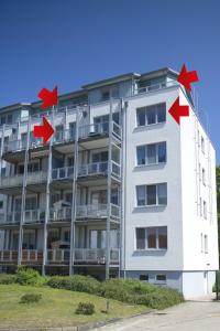 ein weißes Gebäude mit roten Pfeilen auf der Seite in der Unterkunft Zinnowitz Haus Zur Duene Wohnung 14 W14ZDL in Zinnowitz