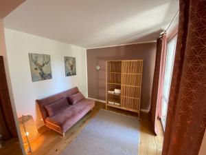 ein Wohnzimmer mit einem lila Sofa und einem Fenster in der Unterkunft Ferienwohnung am Burgberg in Marquartstein