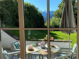 Blick auf einen Tisch und Stühle aus dem Fenster in der Unterkunft Ferienwohnung am Burgberg in Marquartstein