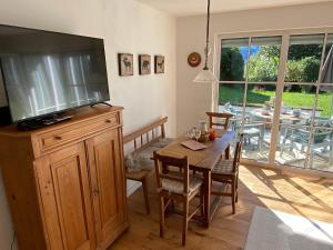 ein Esszimmer mit einem Tisch und einem großen Flachbild-TV in der Unterkunft Ferienwohnung am Burgberg in Marquartstein