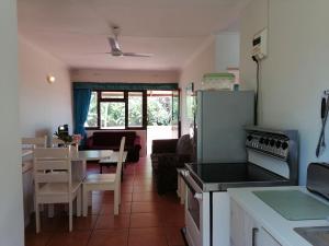 cocina y sala de estar con mesa y nevera en All the Tides - Between Tides, en Margate