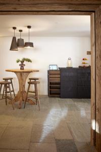 a kitchen with a table and some stools at Berghuus Radons in Savognin