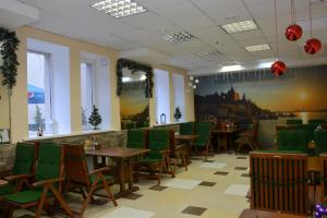 a dining room with tables and green chairs at Karavella in Mykolaiv