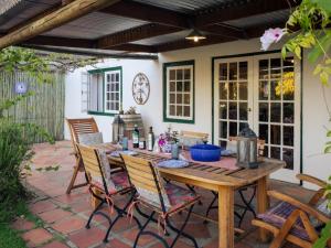 ein Holztisch und Stühle auf einer Terrasse in der Unterkunft Alpha Excelsior Guest Farm in Cederberg + 67 Fotos